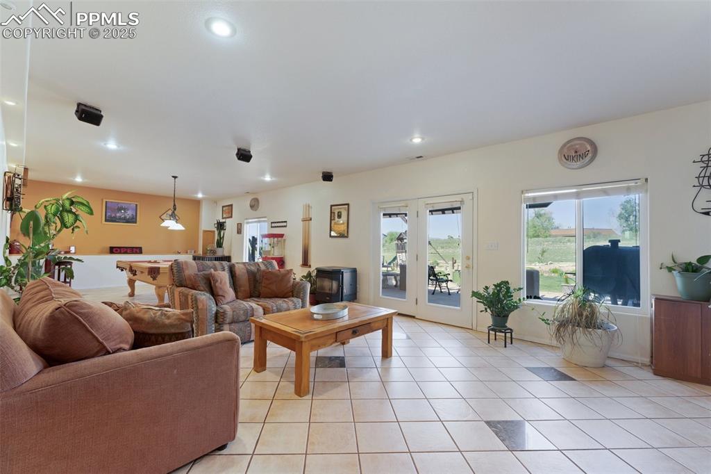 Image 32 of 44: Bright Basement Level Family Room with Built-Ins and Walkout to Concrete Pa