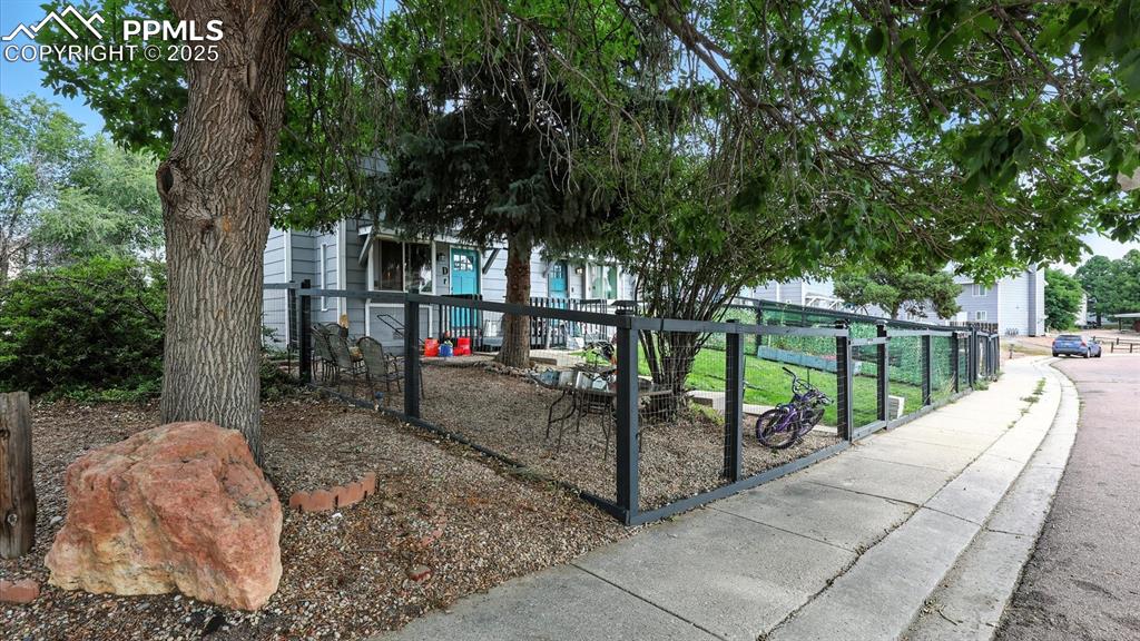 Image 2 of 29: Private fenced lot with mature trees for shade.