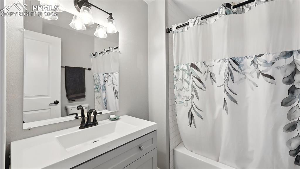 Image 21 of 29: Upper Level Full Bathroom with vanity, mirror, and tiled tub/shower.