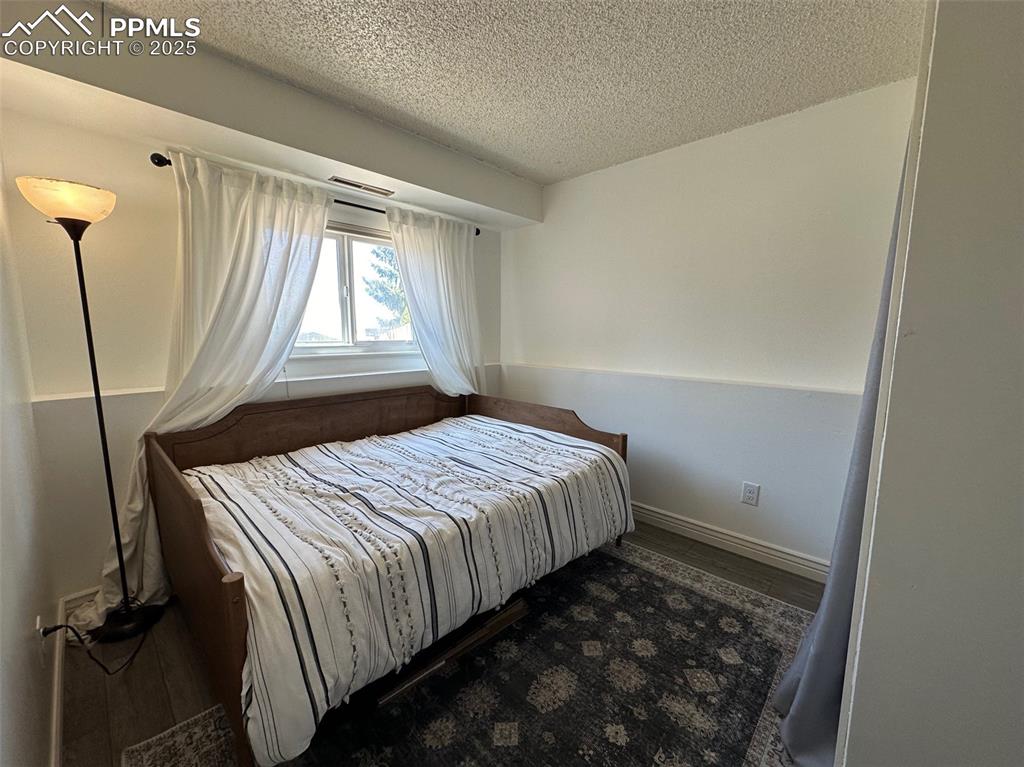 Image 14 of 14: Bedroom with a textured ceiling, wood finished floors, and baseboards