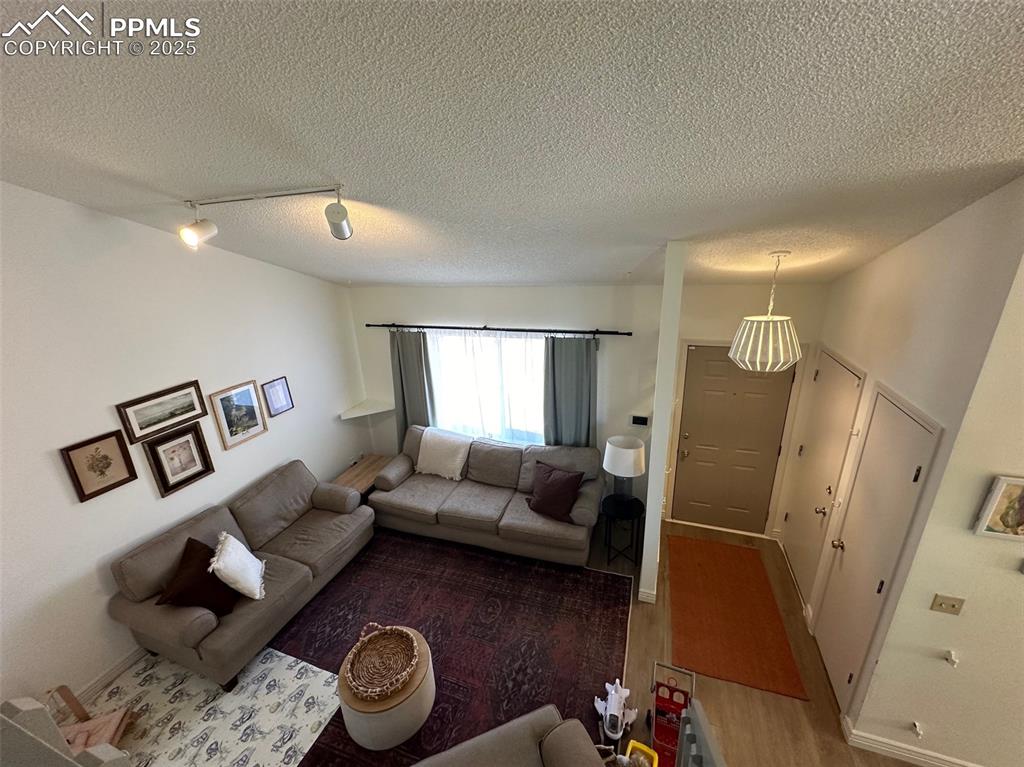 Image 5 of 14: Living room featuring track lighting, a textured ceiling, wood finished flo