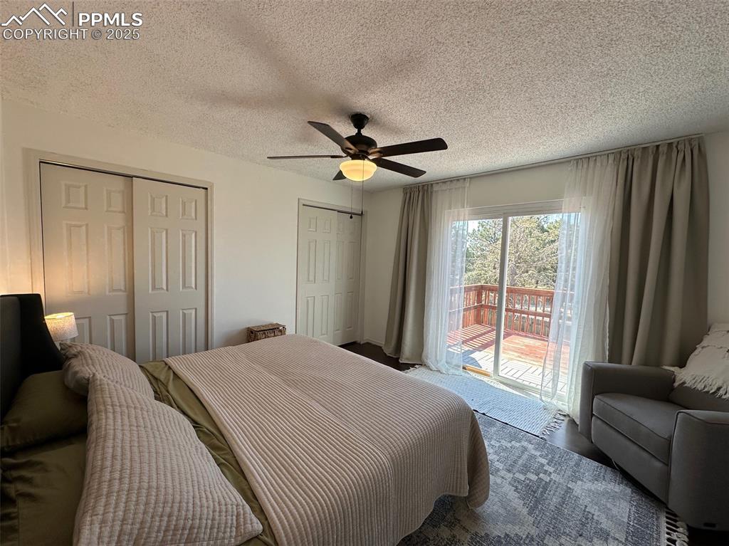 Image 6 of 14: Carpeted bedroom featuring access to outside, multiple closets, ceiling fan