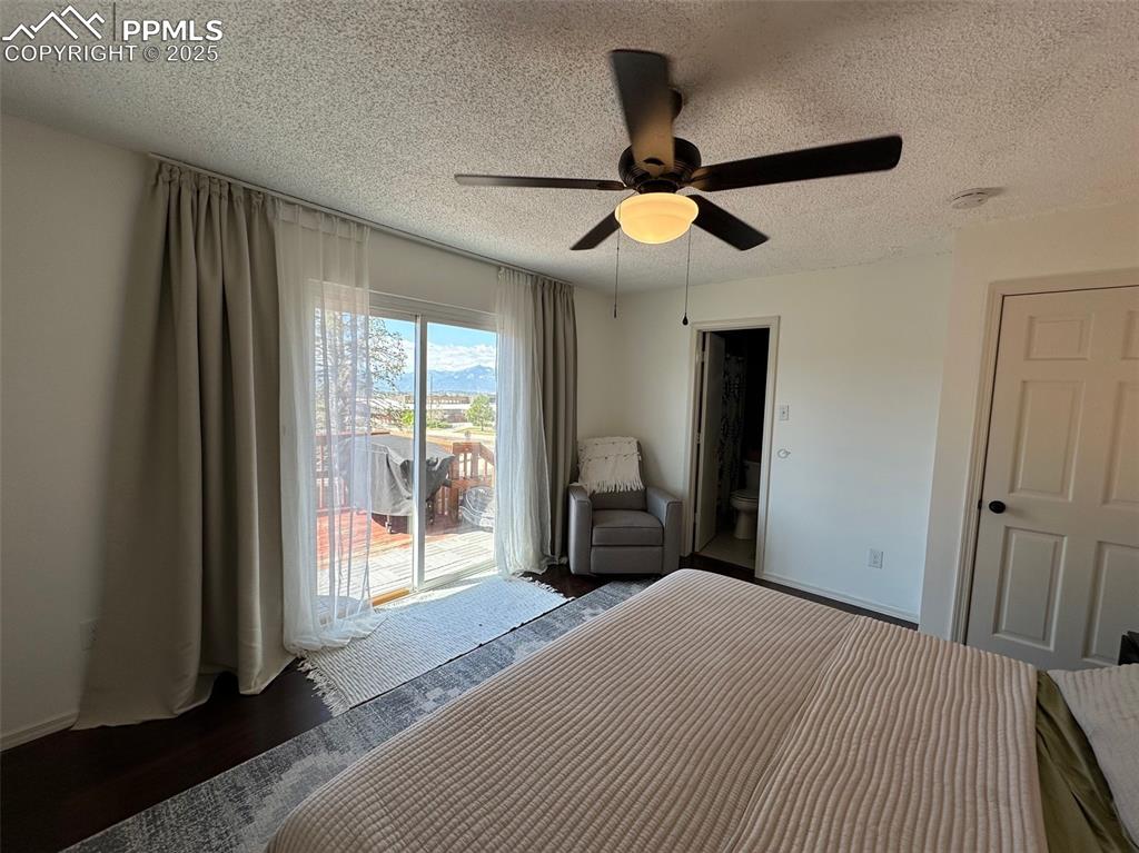 Image 8 of 14: Bedroom with access to exterior, a textured ceiling, a ceiling fan, and woo