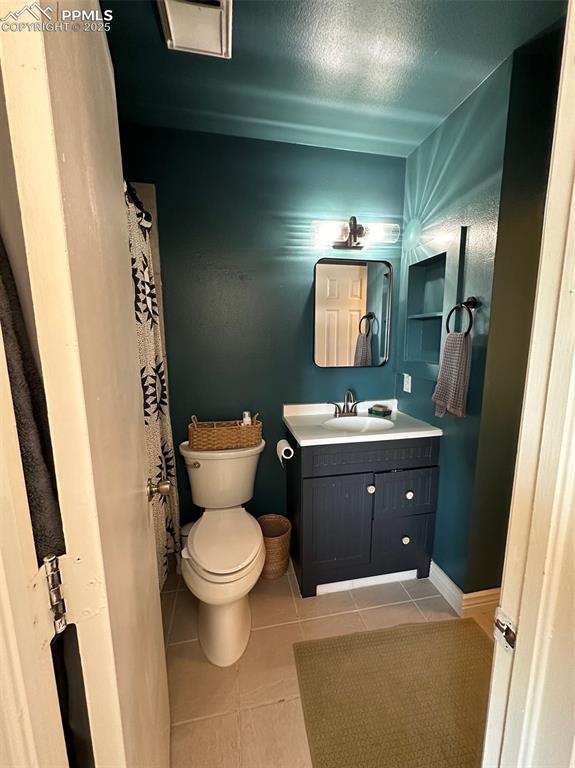 Image 9 of 14: Bathroom with tile patterned floors, vanity, toilet, and a textured ceiling
