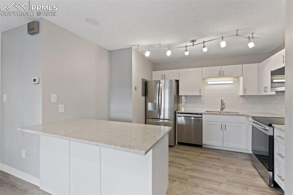 Image 8 of 15: Light & bright kitchen with bright quartz countertops and stainless steel a