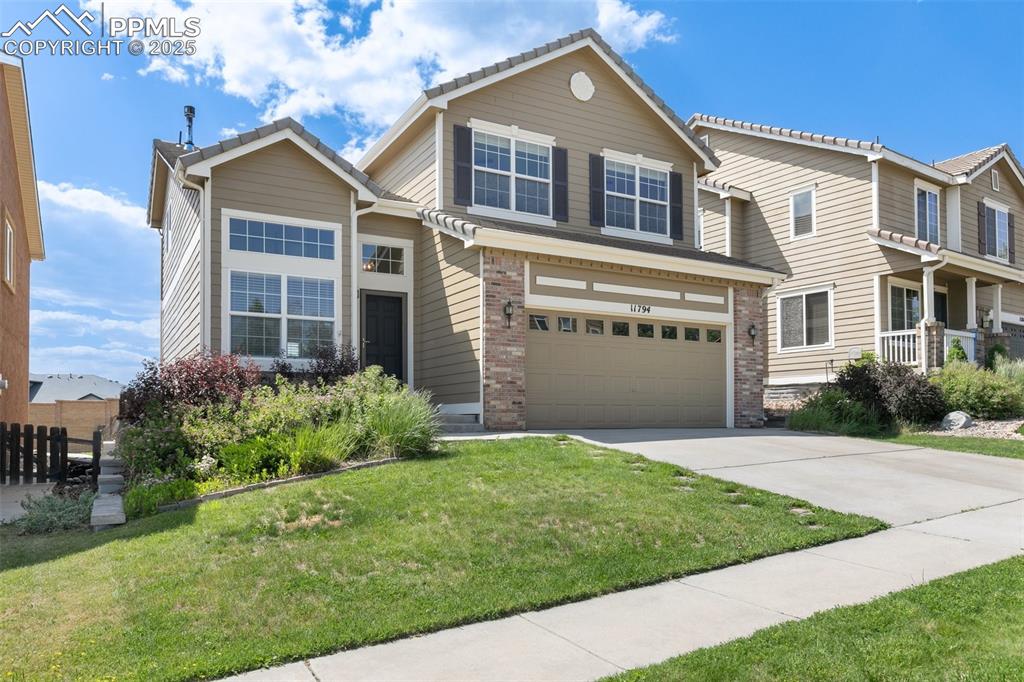 Caption: View of front of property with concrete driveway, a garage, and brick siding