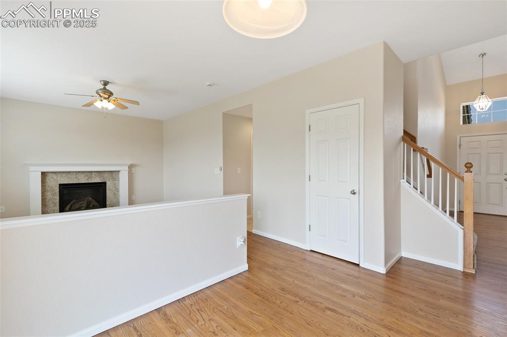 Image 10 of 45: Unfurnished living room with ceiling fan, light wood finished floors, a til