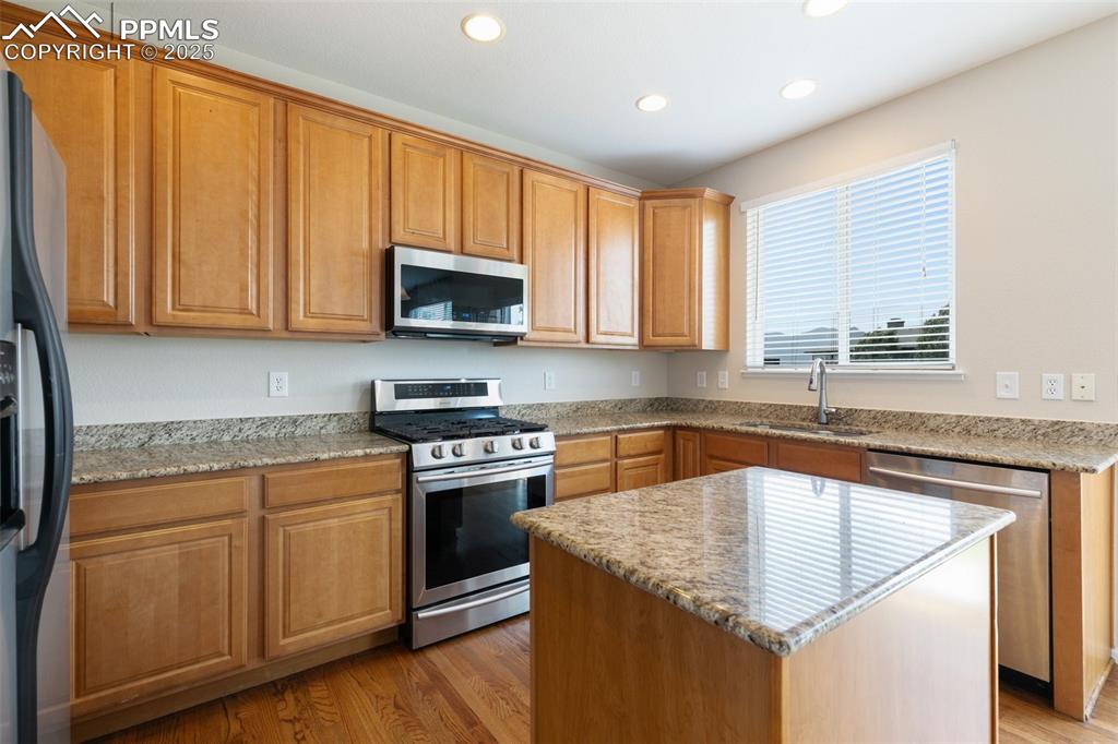 Image 16 of 45: Kitchen with appliances with stainless steel finishes, recessed lighting, l