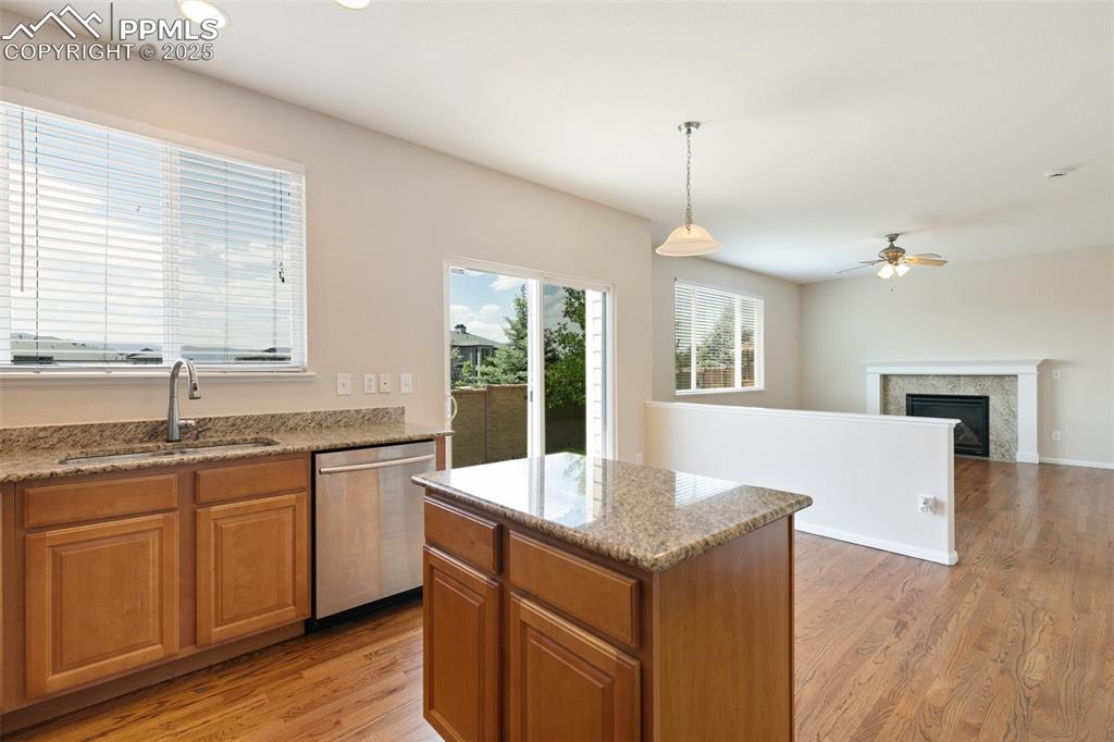 Image 19 of 45: Kitchen with stainless steel dishwasher, a ceiling fan, light wood-style fl