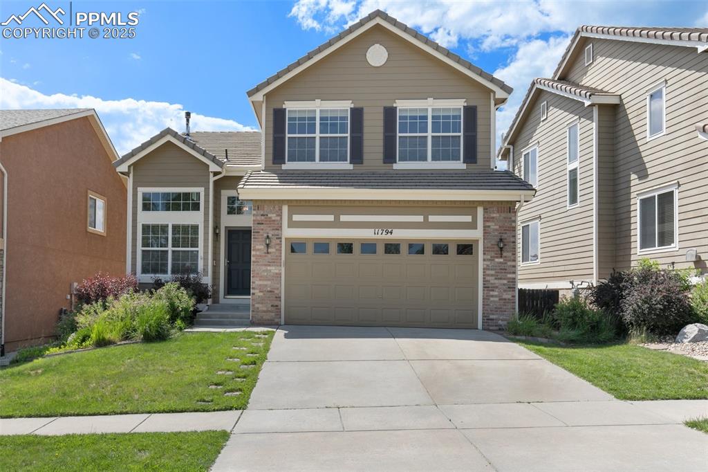 Image 2 of 45: View of front of home featuring brick siding, driveway, a front lawn, an at