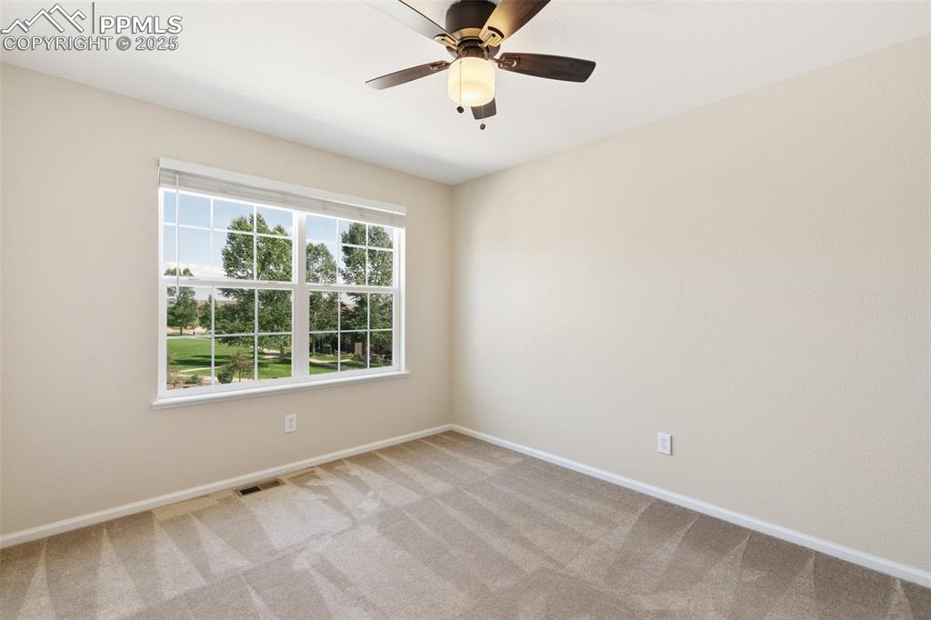 Image 27 of 45: Empty room featuring light colored carpet and a ceiling fan