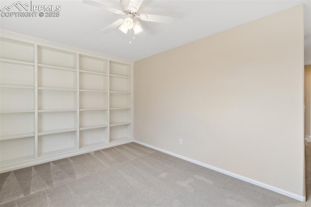 Image 34 of 45: Spare room with carpet, a ceiling fan, and built in shelves