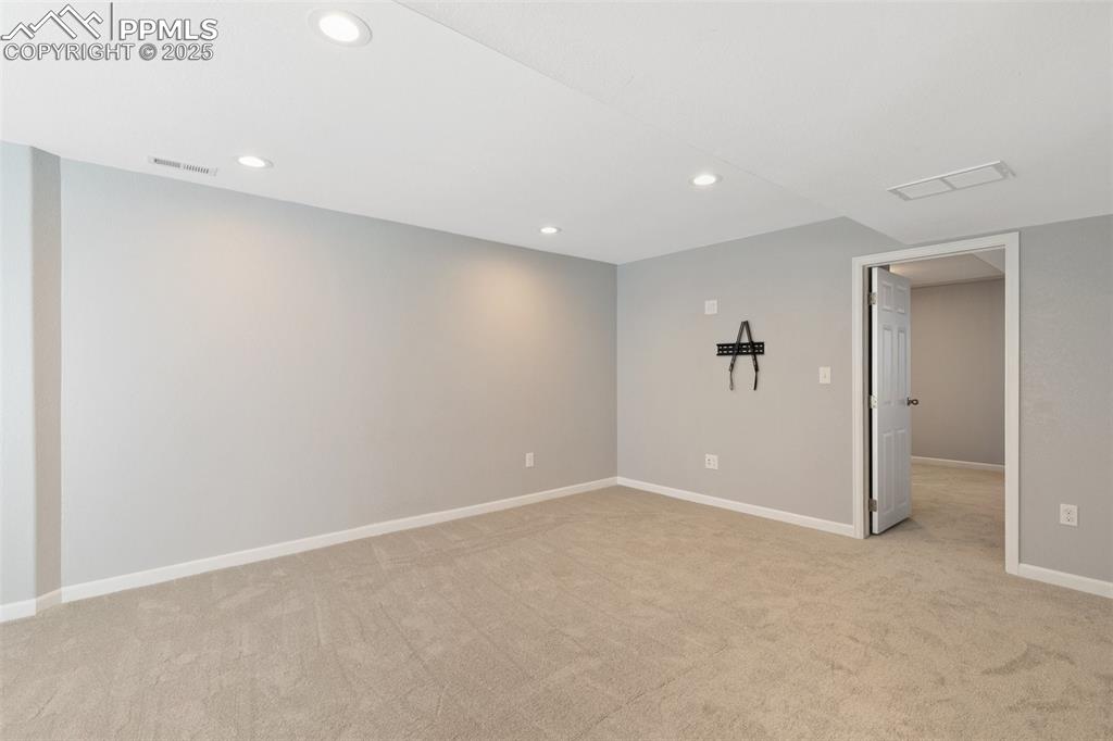 Image 35 of 45: Empty room with light carpet and recessed lighting