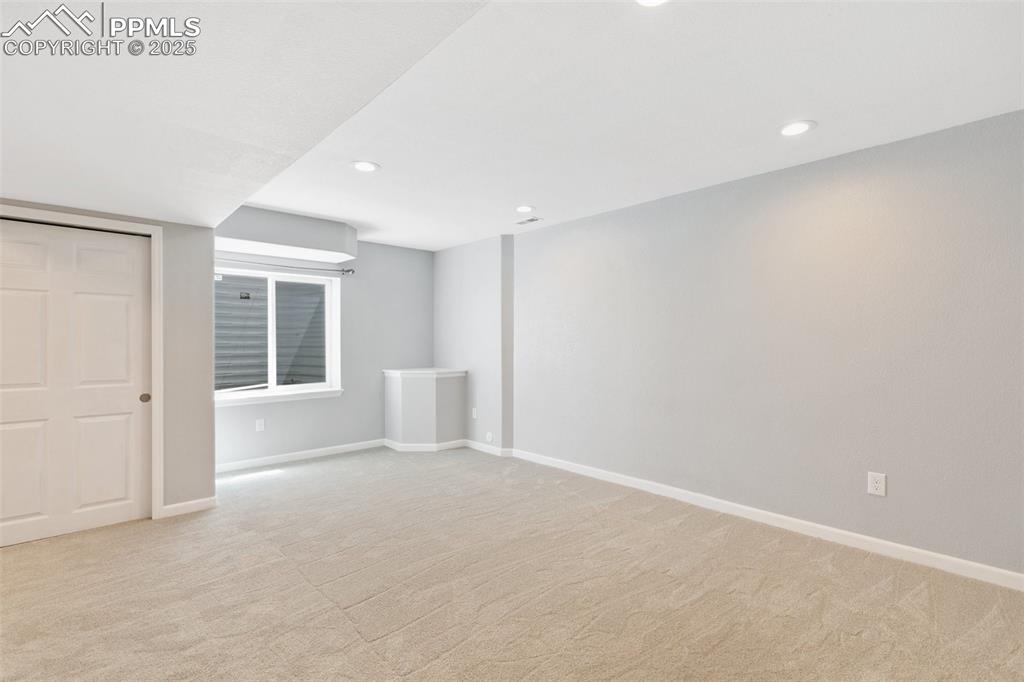 Image 36 of 45: Below grade area with light carpet and recessed lighting