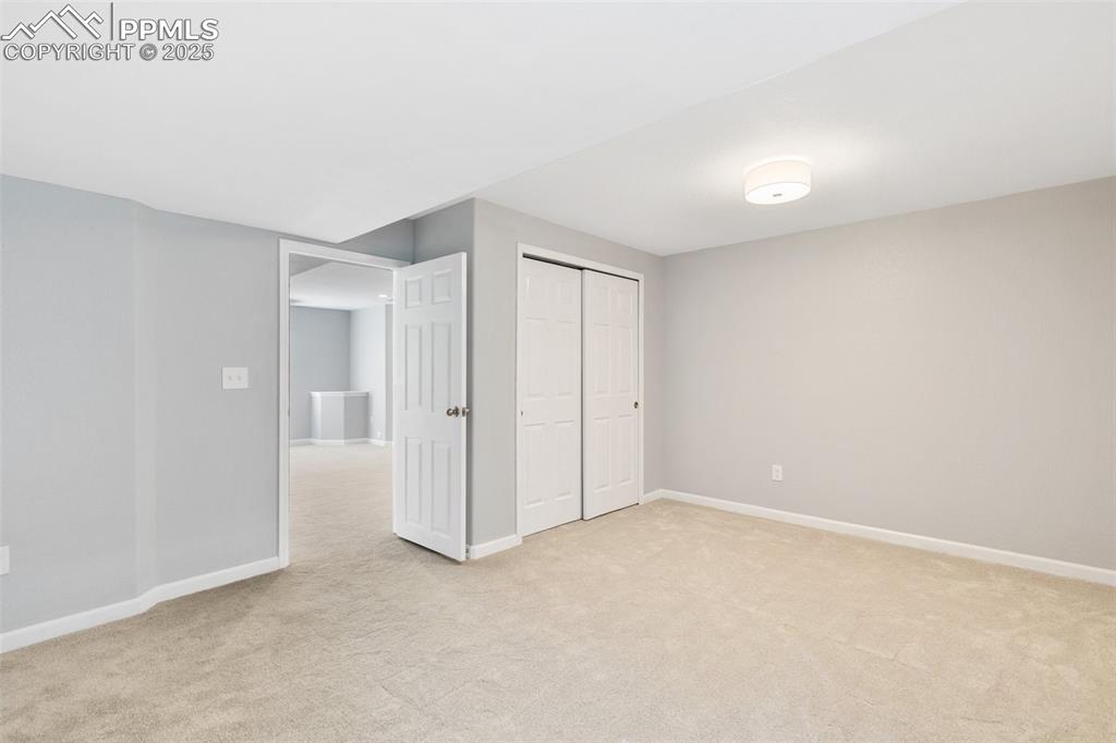 Image 42 of 45: Unfurnished bedroom with light colored carpet and a closet