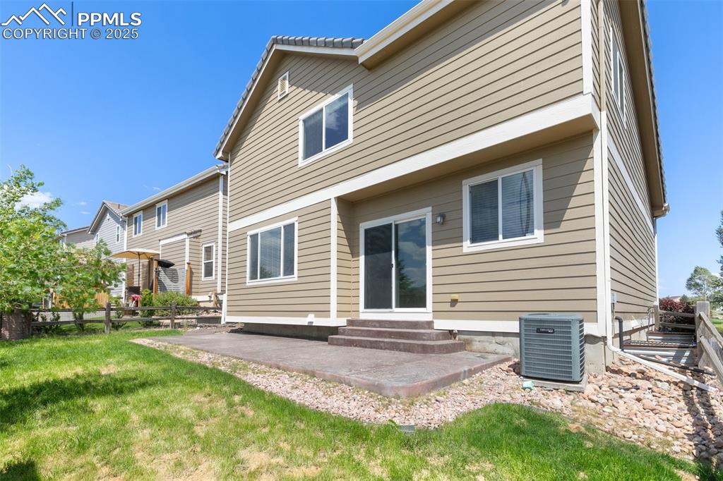 Image 44 of 45: Rear view of house with entry steps, a patio, and a fenced backyard