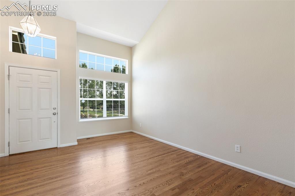Image 5 of 45: Entrance foyer featuring a high ceiling and wood finished floors