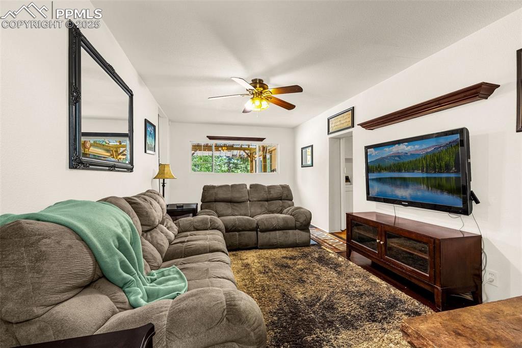 Image 11 of 31: Living area featuring a ceiling fan and built in shelves