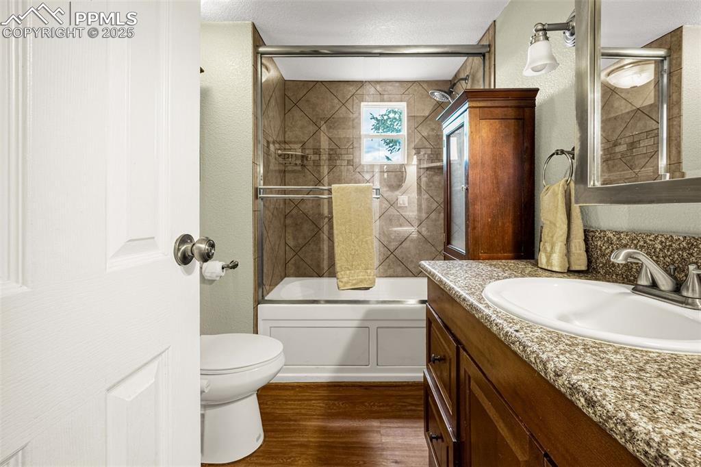 Image 13 of 31: Full bathroom with vanity, wood finished floors, and shower / bath combinat