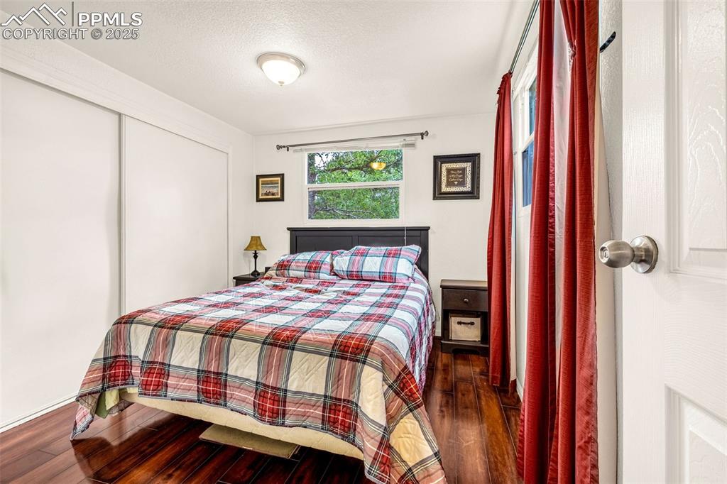 Image 15 of 31: Bedroom with wood finished floors, a closet, and a textured ceiling