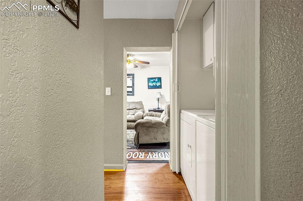 Image 17 of 31: Hallway featuring a textured wall, washing machine and clothes dryer, and l