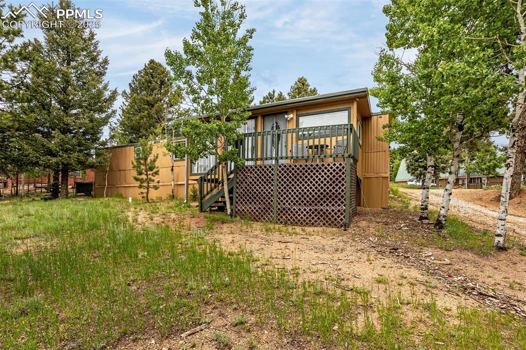 Image 27 of 31: Rear view of property featuring stairs and a wooden deck