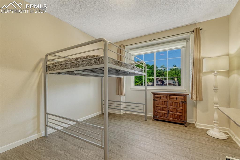 Image 19 of 31: Bedroom featuring vaulted ceiling, wood finished floors, ceiling fan, and a