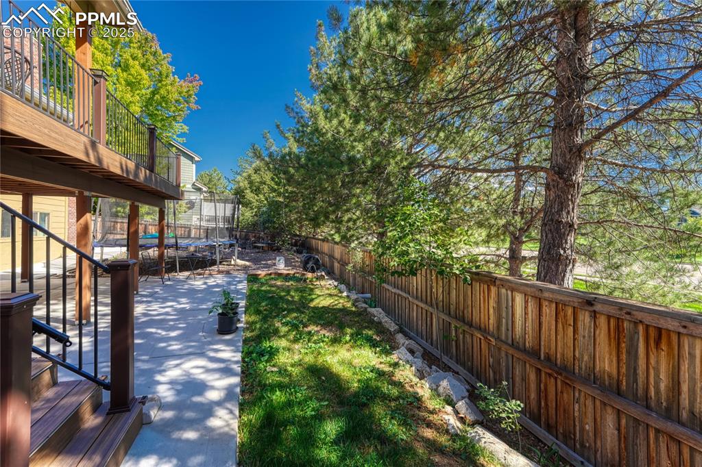 Image 28 of 31: Fenced backyard featuring a patio area, a balcony, and a trampoline