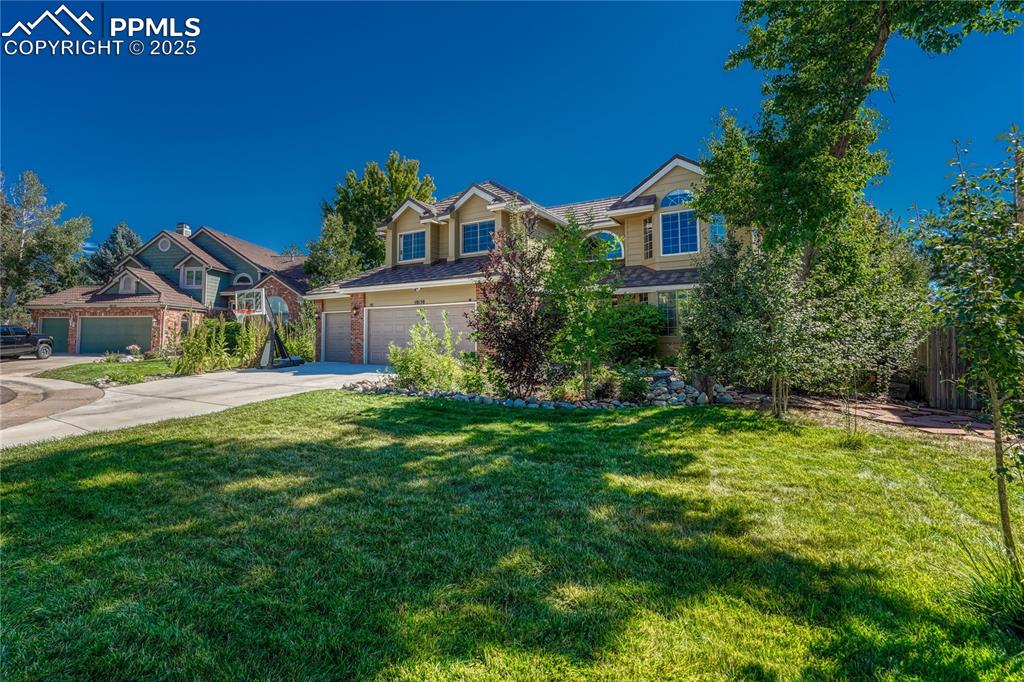 Image 3 of 31: Traditional-style home with concrete driveway and a front yard