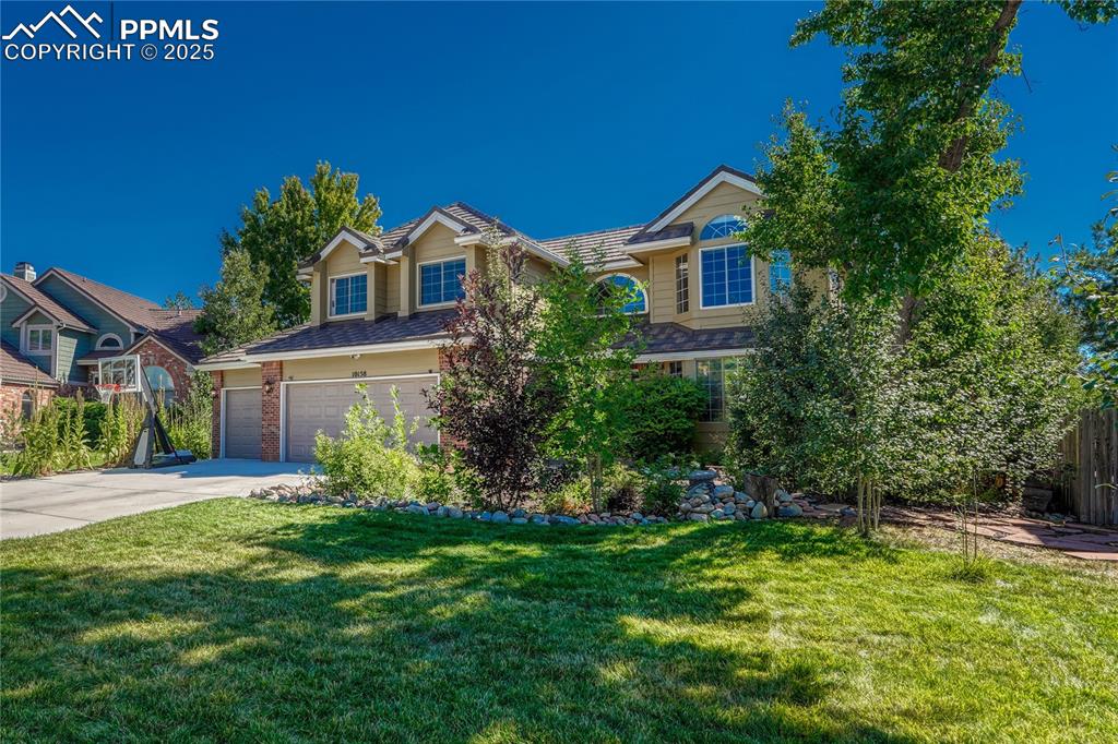 Image 4 of 31: View of front of property featuring concrete driveway, a front yard, and a