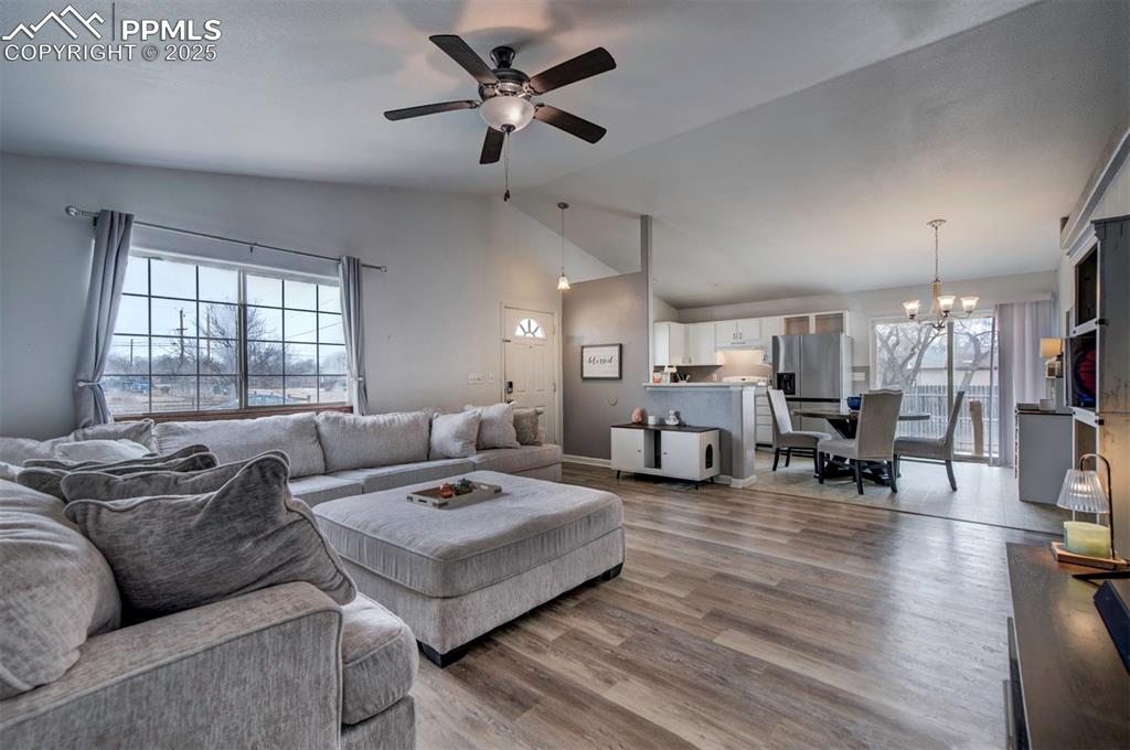 Image 10 of 25: Living area featuring baseboards, high vaulted ceiling, ceiling fan with no