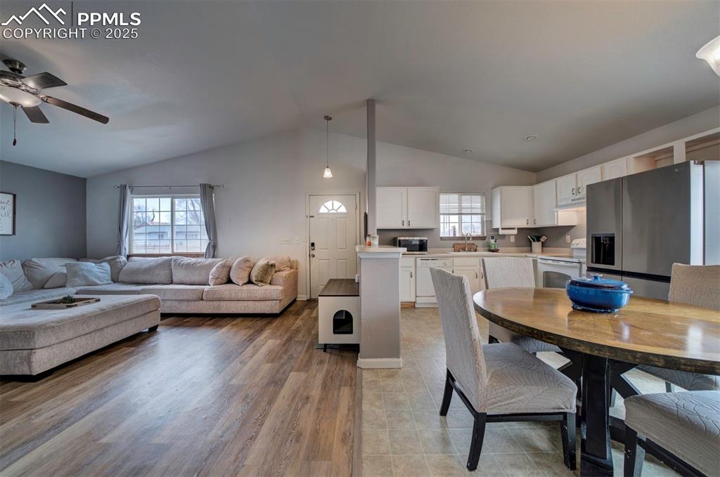 Image 13 of 25: Dining space with light wood-style flooring, ceiling fan, and vaulted ceili