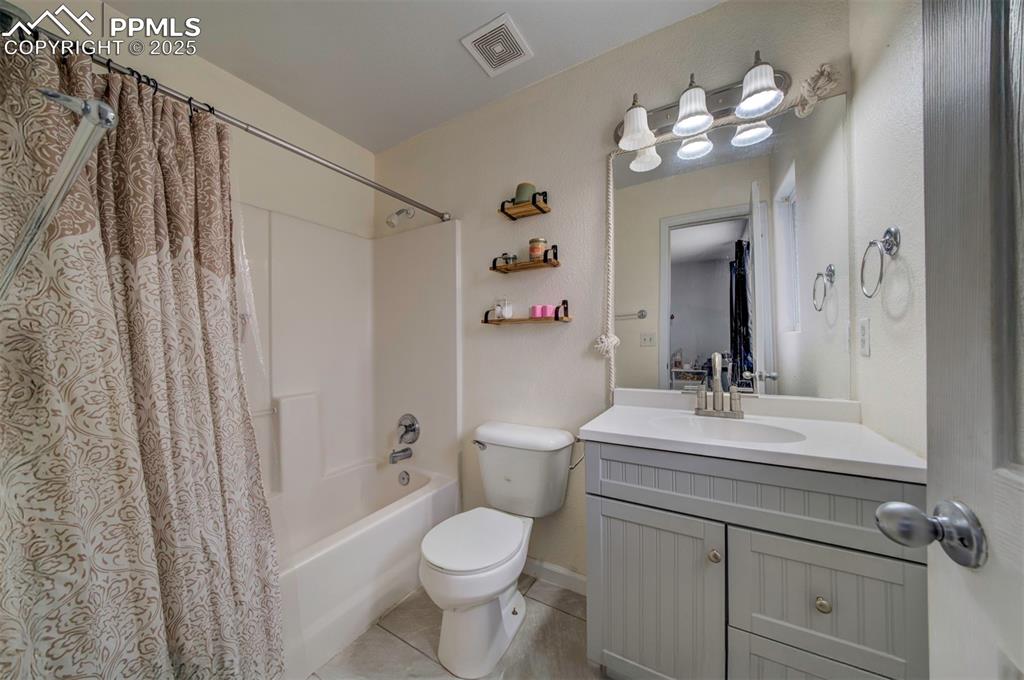 Image 20 of 25: Full bath with vanity, shower / bathtub combination with curtain, visible v