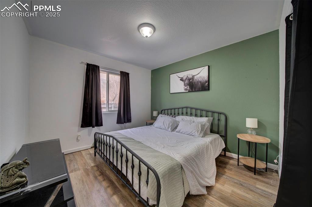 Image 23 of 25: Bedroom featuring wood finished floors and baseboards