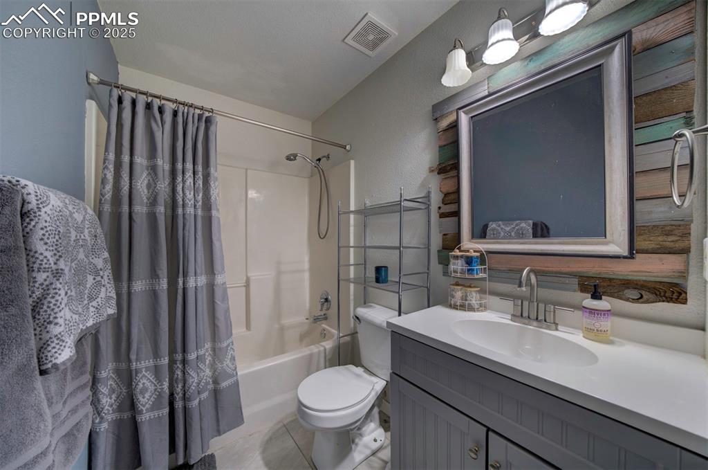 Image 24 of 25: Full bathroom with vanity, visible vents, tile patterned flooring, toilet,