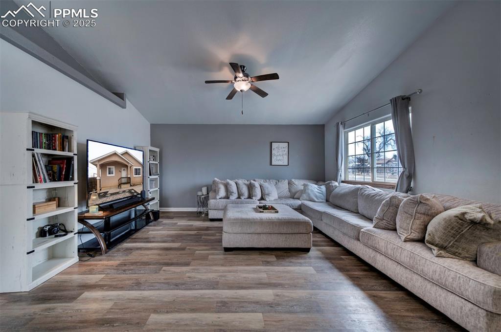 Image 7 of 25: Living room featuring lofted ceiling, ceiling fan, and baseboards