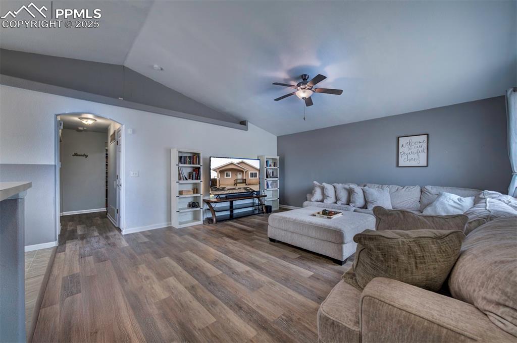 Image 9 of 25: Living room with arched walkways, vaulted ceiling, ceiling fan