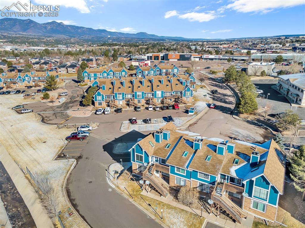 Image 13 of 13: Aerial view of residential area featuring a mountainous background