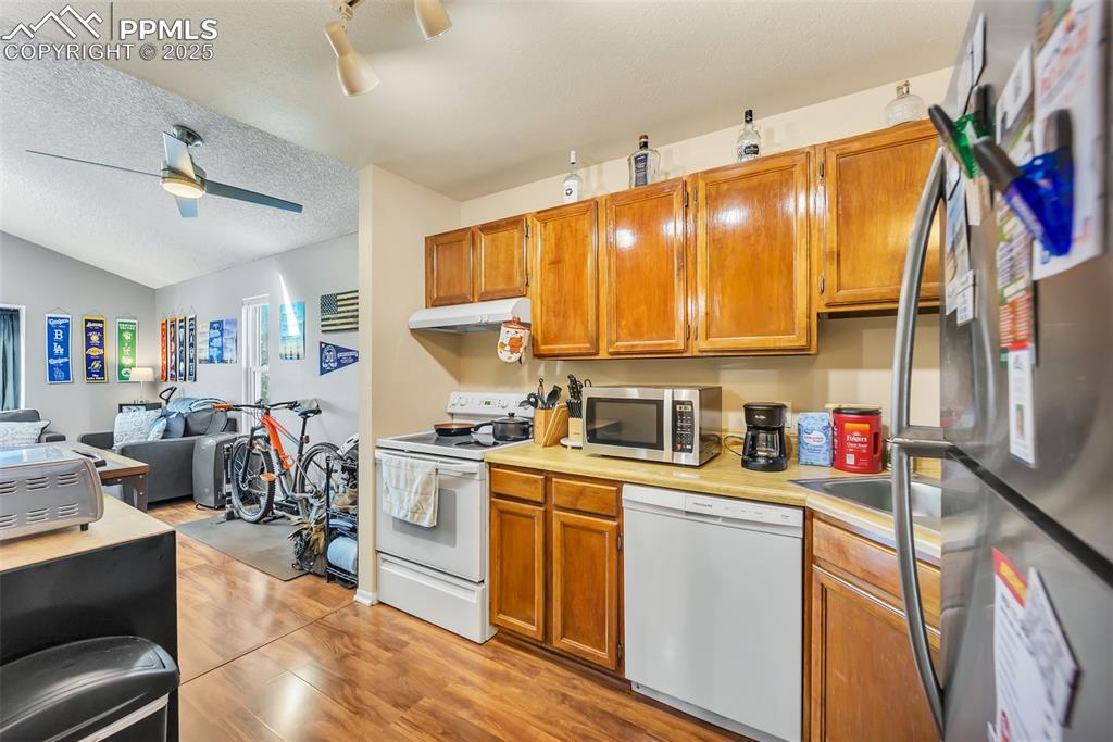 Image 3 of 13: Kitchen with appliances with stainless steel finishes, open floor plan, lig