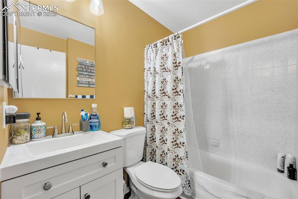 Image 8 of 13: Full bathroom with vanity and shower / bath combination with curtain