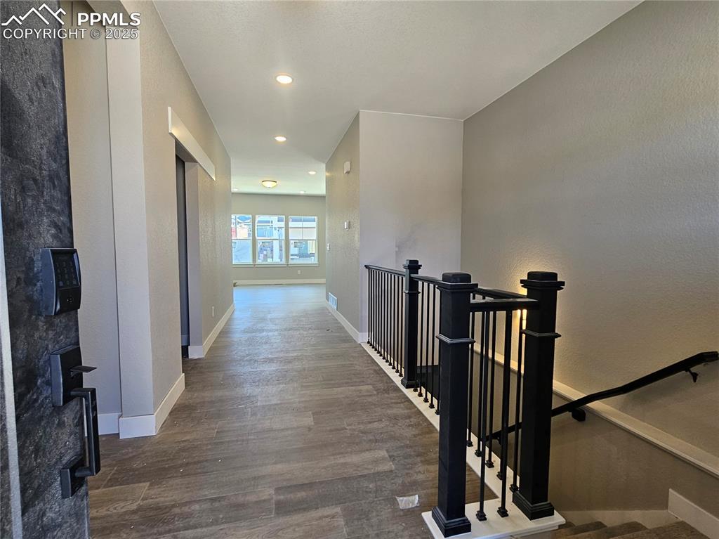 Image 2 of 12: Hall featuring an upstairs landing, wood finished floors, recessed lighting