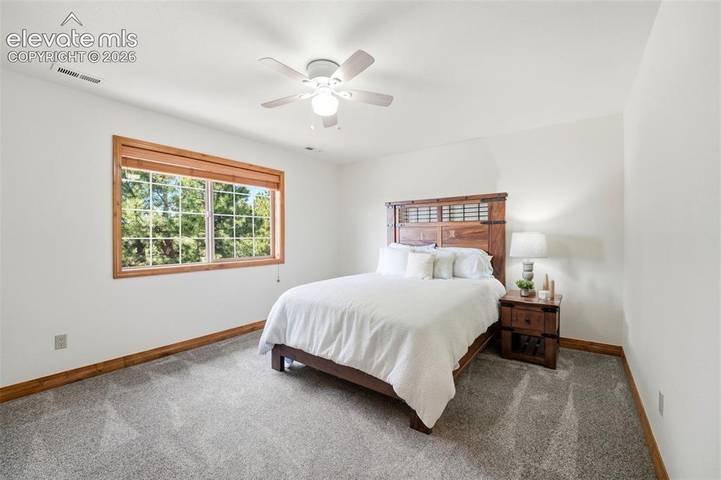 Image 19 of 50: Soaking tub with tiled surround, large window with natural wood trim, light