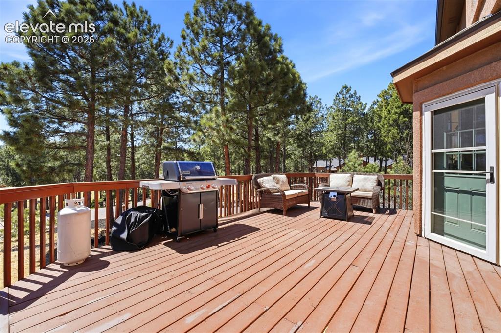 Image 41 of 50: Expansive covered deck featuring a wood-finish floor and sturdy support col