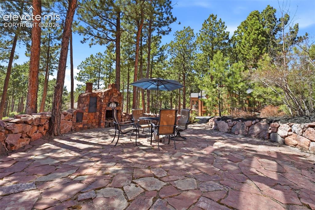 Image 45 of 50: Expansive flagstone patio featuring a built-in stone pizza oven and stone r