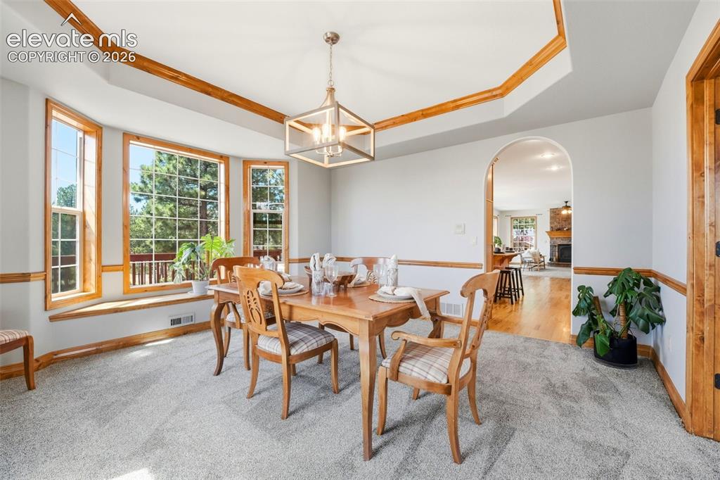 Image 8 of 50: Kitchen featuring wood cabinetry with crown molding, granite countertops, s