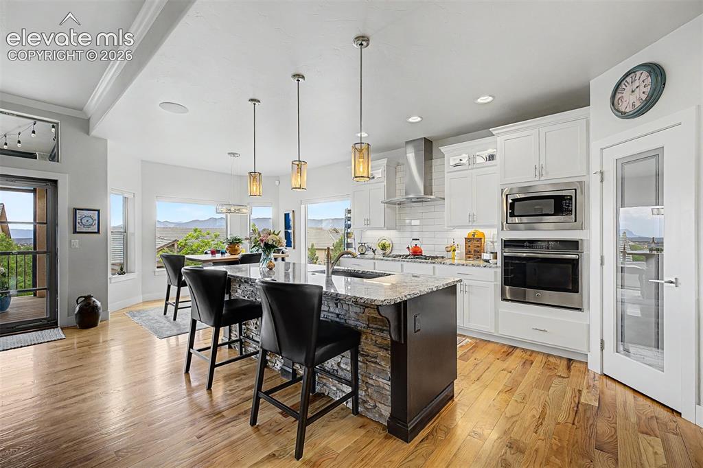 Image 15 of 49: Open kitchen and dining area, with a walk out to a large, covered patio whi