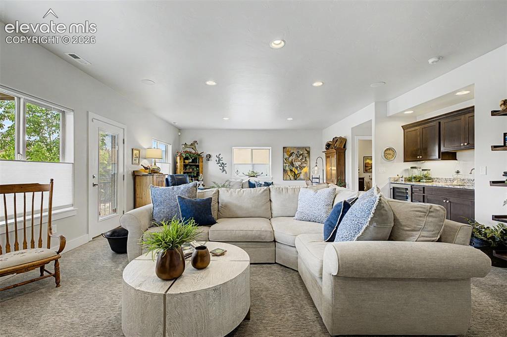 Image 28 of 49: A large family room with a great wet bar, walk out to the beautiful, gated
