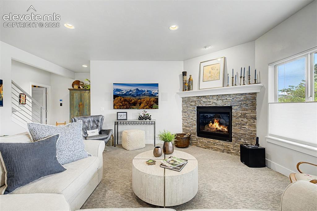 Image 29 of 49: Large family room with beautiful fireplace and lots of natural light.
