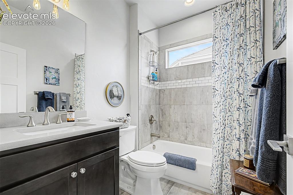 Image 34 of 49: Beautiful tiling and quartz countertop make for a beautiful guest bathroom.