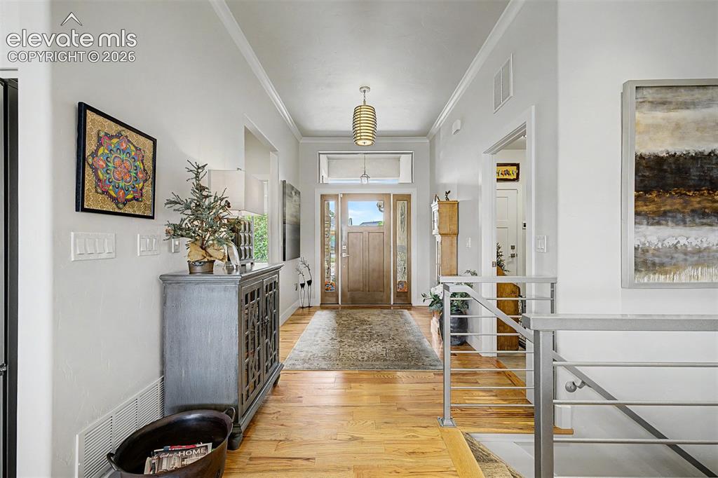 Image 5 of 49: Long entry hallway with beautiful wood floors.